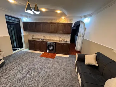 a living room with a couch and a kitchen at شقه للإيجار قرب جامعة اليرموك in Irbid