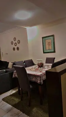 a dining room with a table and a couch at شقه مفروشه بالكامل مكونه من 4 غرف في ضاحيه الأمير راشد عمان شارع مكه in Amman