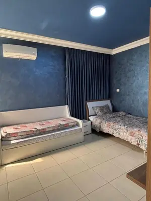 a bedroom with two beds and a blue wall at فيلا مميزة في عمان - Special Villa in Amman in Amman