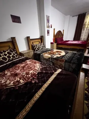 a bedroom with two beds and a chair at Salem Guesthouse Experience in Al Ḩayy