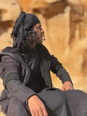 a man with a beard sitting on the ground at Salem Guesthouse Experience in Al Ḩayy