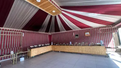 a red and white tent with a table in it at Wadi Rum Luxury Trend in Wadi Rum