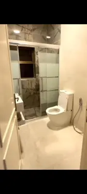 a bathroom with a white toilet and a sink at Dair Ighbar Apartment