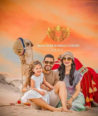 a group of people sitting on the beach with a camel at WADI RUM BUBBLES lUXURY CAMP in Disah