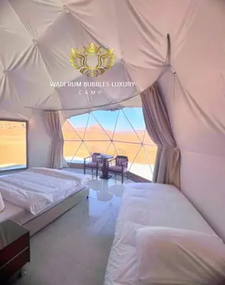a bedroom with two beds in a tent at WADI RUM BUBBLES lUXURY CAMP in Disah