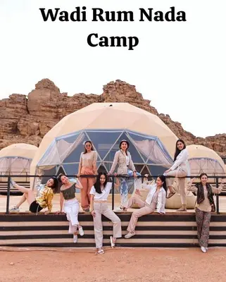 a group of women sitting on steps in front of a tent at Wadi Rum Nada Camp in Wadi Rum