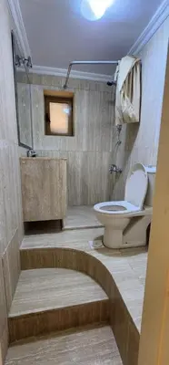 a bathroom with a toilet and a sink at Horizon 3 in Al Qarţū‘īyah