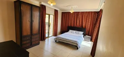 a bedroom with a bed and a dresser and a window at Horizon 3 in Al Qarţū‘īyah
