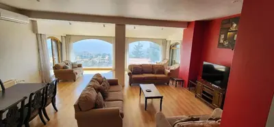 a living room filled with furniture and a large window at Horizon 3 in Al Qarţū‘īyah
