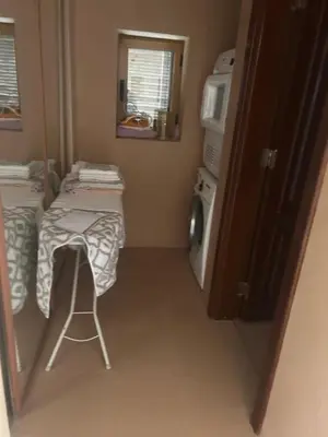 a small kitchen with a table and a microwave at Horizon 3 in Al Qarţū‘īyah