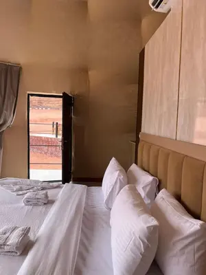 a bedroom with a bed with white sheets and pillows at Wadi rum camp teem in Wadi Rum