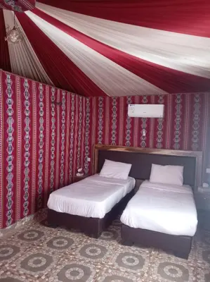 two beds in a room with a tent at Wadi rum camp teem in Wadi Rum
