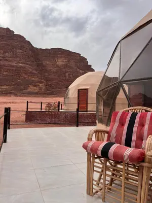 a chair sitting on a patio with a dome at Wadi rum camp teem in Wadi Rum
