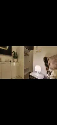 a room with a bed and a table with a lamp at Qqq in Amman