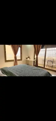 a bedroom with a bed and a window with curtains at Qqq2 in Amman