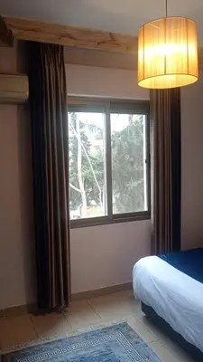 a bedroom with a bed and a large window at Studio at the heart of Jabl Amman in Amman