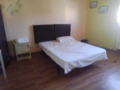 a bedroom with a white bed and a wooden floor at Petra Neighbor Hostel in Wadi Musa