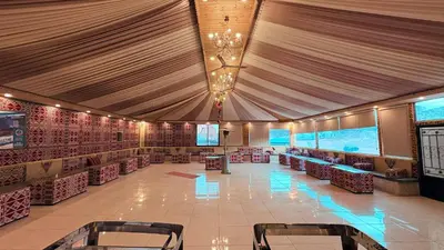 a large room with a tent with tables and chairs at Hello Desert Camp & Tour