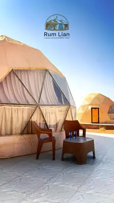 a tent with two chairs and a table in front at Rum Lian Luxury Camp & Bubble Hotel in Disah