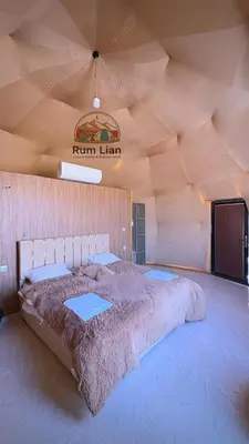 a large bed in a room with a wooden ceiling at Rum Lian Luxury Camp & Bubble Hotel in Disah