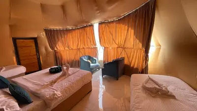 a bedroom with two beds and a window at Wadi Rum -Lekshary Hamza 55 in Wadi Rum