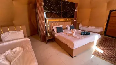 two beds in a room with two swans on them at Wadi Rum -Lekshary Hamza 55 in Wadi Rum