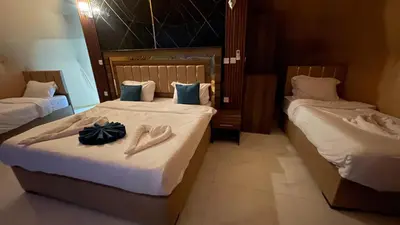 two beds in a hotel room with shoes on them at Wadi Rum -Lekshary Hamza 55 in Wadi Rum
