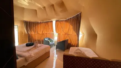 a small bedroom with a bed and a window at Wadi Rum -Lekshary Hamza 55 in Wadi Rum