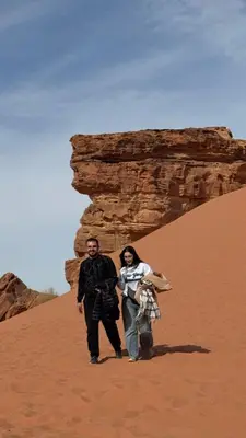 a man and a woman standing in the desert at Monte Carlos Luxury Camp in Disah