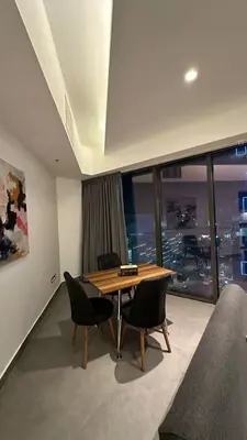 a dining room with a table and chairs and a window at Rashed's apartments at DAMAC Tower in Amman