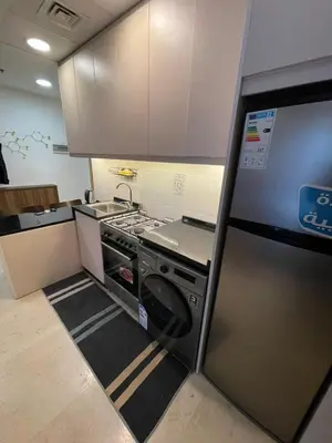 a small kitchen with a stove and a refrigerator at luxury apartments at DAMAC tower amman للعائلات برج داماك in Amman