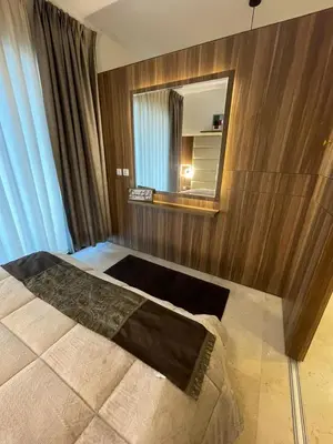 a bedroom with a large bed with a mirror at luxury apartments at DAMAC tower amman للعائلات برج داماك in Amman