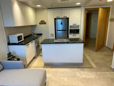 a kitchen with a refrigerator and a counter top at luxury apartments at DAMAC tower amman للعائلات برج داماك in Amman
