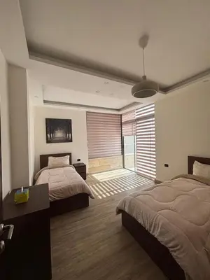 a bedroom with two beds and a large window at شقة مميزة في عبدون هيلز-Modern Apartment in Abdoun Hills in Amman