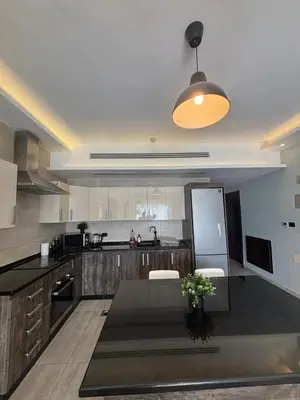 a kitchen with a table and a counter top at شقة مميزة في عبدون هيلز-Modern Apartment in Abdoun Hills in Amman