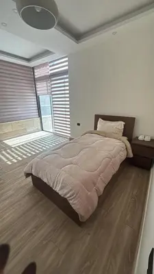 a bedroom with a large bed and a large window at شقة مميزة في عبدون هيلز-Modern Apartment in Abdoun Hills in Amman