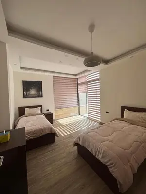 a bedroom with two beds and a large window at شقة مميزة في عبدون هيلز-Modern Apartment in Abdoun Hills in Amman