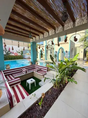 an outdoor patio with a pool and a table at Sultana Villa by Seahorse in Al Rama