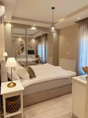a bedroom with a large bed and a living room at 24h security, family friendly remodeled cozy space in Amman