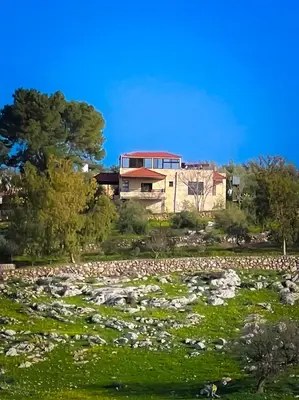 a house on a hill with a field of rocks at Um Al Namel Villa & Chalet