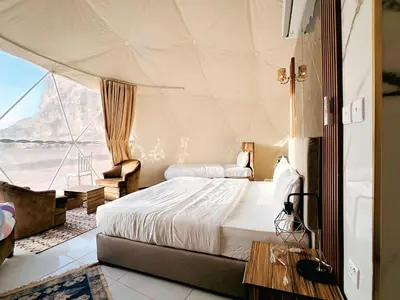 a bedroom with two beds in a tent at Wadi Rum Guide , Luxury Camp