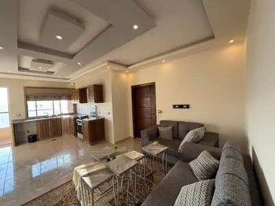 a living room with a couch and a table at شقة للإيجار في راس منيف - عجلون in Ajloun