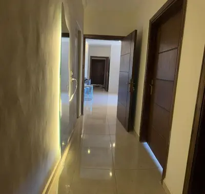 a hallway with two doors and a room with a table at شقة للإيجار في راس منيف - عجلون in Ajloun