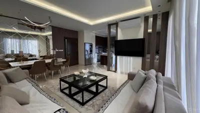 a living room with a white couch and a table at Modern apartment near the UK embassy in abdoun in Amman