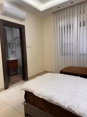a bedroom with a bed and a window with a mirror at Modern apartment near the UK embassy in abdoun in Amman