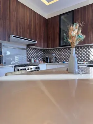 a kitchen with a vase of flowers on a counter at Modern apartment near the UK embassy in abdoun in Amman