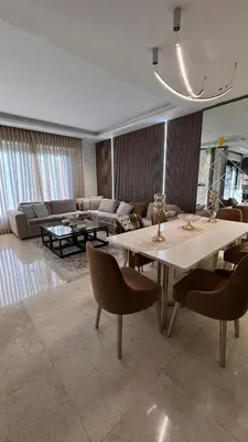 a living room with a table and a couch at Modern apartment near the UK embassy in abdoun in Amman
