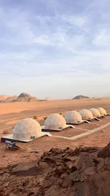 a row of white tents in the desert at Yazeed in Disah