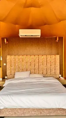a bedroom with a bed with an orange wall at Yazeed in Disah