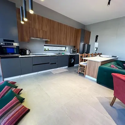 a kitchen with a green couch and a kitchen with a counter at Haifa Villa by Seahorse in Sowayma